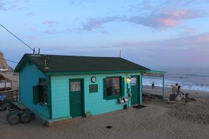 une maison verte, au bord  de la plage