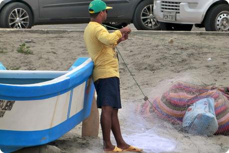 pêcheur rangeant son filet de pêche sur la plage de Pedernales