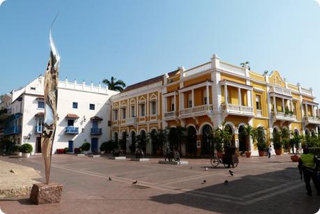 bâtiment jaune et place avec des sculptures dans le centre-ville de Carthagène